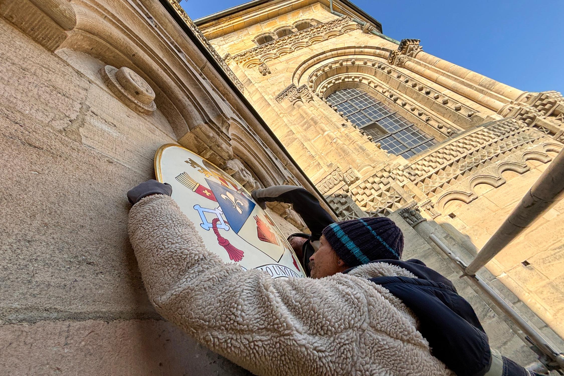 Ein Team der Bamberger Dombauhütte bringt das Papstwappen von Papst Leo XIV. am Adamsportal des Bamberger Doms an. Papstwappen Dom